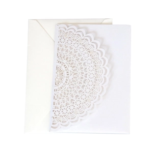 Close-up of laser-cut mandala lace pattern on white wedding invitation suite