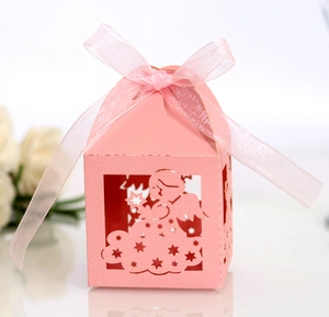 Detailed laser-cut angel candy box in pink paper with elegant silk ribbon bow