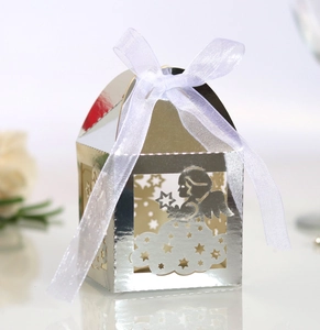 Detail of silver hollow candy box with angel and star cutouts and white organza ribbon