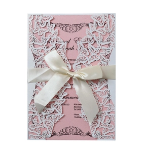 Detail of laser cut butterfly wedding invitation with silk bow and floral insert