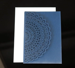 Detail of laser-cut mandala lace pattern on deep blue card with white inner sheet