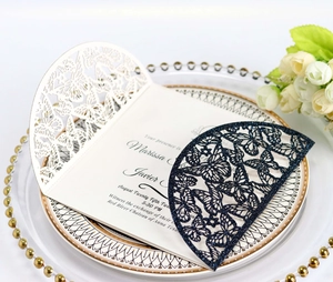 Macro shot of laser-cut butterfly invitation envelopes on a decorative pearl plate