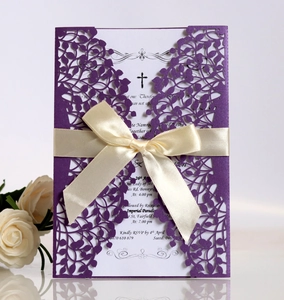 Detail of laser-cut purple invitation with beige ribbon bow and elegant white rose