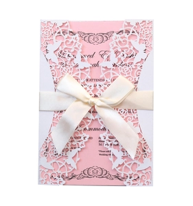 Detail of pink wedding invitation with white laser-cut butterfly cover and ivory ribbon
