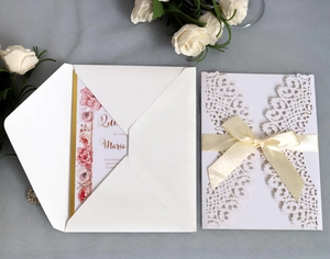 Elegant laser cut wedding invitation with white floral lace sleeve and beige satin bow