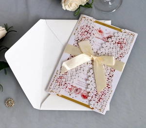 Elegant laser-cut blue wedding invitation card with ribbon bow and floral envelope set