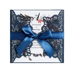 Elegant laser cut navy lace invitation with ribbon bow and floral bird pattern insert
