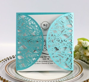 Detailed laser-cut butterfly invitation on blue pearlescent paper with white card insert