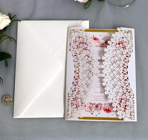 Detailed laser-cut blue wedding invitation with floral shell and pink rose inner card