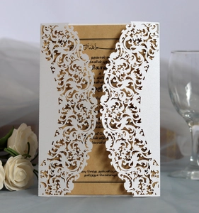 White laser-cut lace invitation card with floral patterns and a kraft paper insert