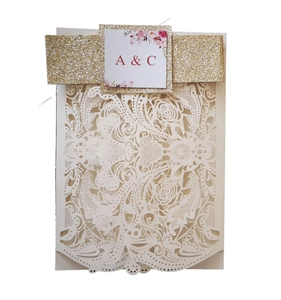 Laser cut wedding invitation in cream white with a sparkling gold glitter belly band