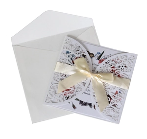 Laser-cut floral butterfly wedding invitation with cream ribbon bow and floral card
