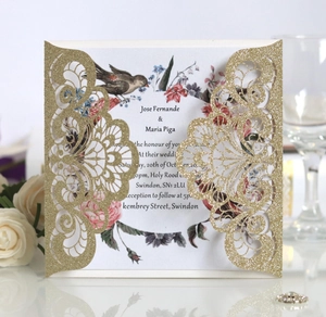 Elegant gold glitter laser cut wedding invitation with intricate lace patterns and floral insert