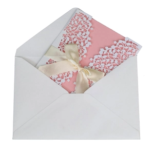 Elegant pink laser-cut wedding invitation with white hollow pattern and satin ribbon bow
