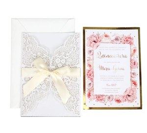 Elegant laser-cut floral invitation set with white lace design and cream ribbon bow