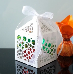 White laser-cut candy gift box with hollow circle patterns and white satin ribbon bow