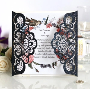 Detail of laser-cut navy glitter wedding invitation with elegant floral inner card