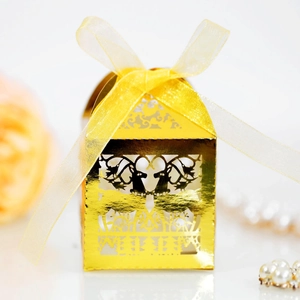 Golden laser-cut Christmas reindeer candy box with yellow organza ribbon on white background