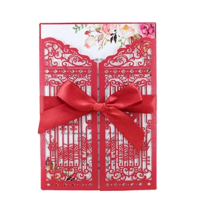 Elegant red laser-cut wedding invitation with satin bow and floral inner card
