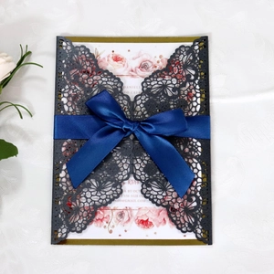 Detail of laser-cut butterfly invitation with royal blue satin ribbon and floral card