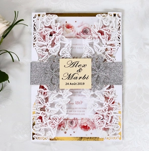 Detail of laser-cut butterfly invitation with silver glitter belt and floral inner card