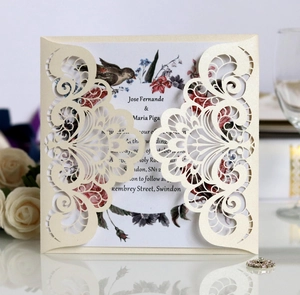 Detail of laser-cut European floral lace wedding invitation with elegant bird inner card