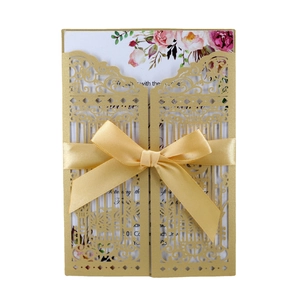 Golden laser cut gate style wedding invitation with elegant ribbon and floral inner card