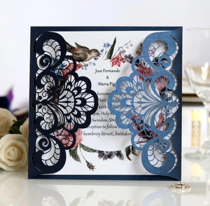 Detailed macro view of laser-cut lace pattern on navy blue pearlescent wedding card