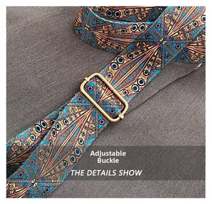 Detail of adjustable wide shoulder strap with ethnic geometric patterns and gold buckle