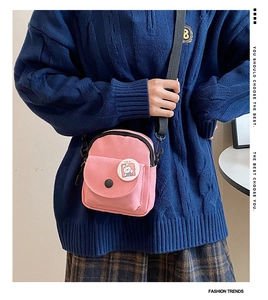 Détail du mini sac bandoulière en toile rose avec badge lapin et sangle noire