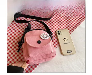 Détail de sac bandoulière en toile rose avec badge dessin animé et comparatif de taille