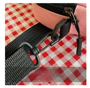 Détail du sac en toile rose avec crochet pivotant en plastique noir et sangle