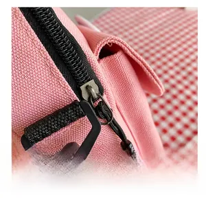 Gros plan sur un sac en toile rose montrant la fermeture éclair et les détails en métal