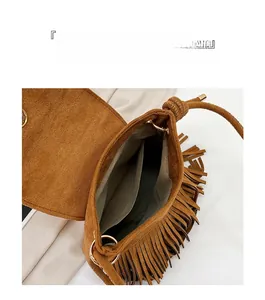 Vue de dessus d'un sac à bandoulière marron avec pompons et compartiments internes