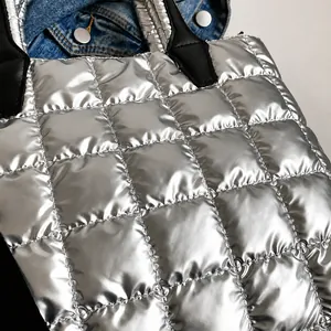 Detail of silver quilted tote bag with metallic finish and square stitching patterns