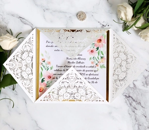 Detail of laser cut lace invitation with gold glitter backing and floral insert