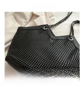 Détail du sac cabas noir à strass avec motif résille et bandoulière chaîne