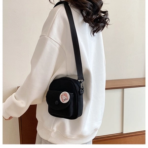 Détail du petit sac bandoulière en toile noire avec broderie lapin et sangle