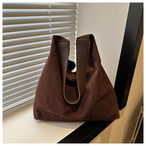 Close-up of matte dark coffee tote bag with leather straps on a white windowsill