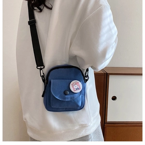 Détail du sac bandoulière en toile bleue avec sangle réglable et badge lapin mignon