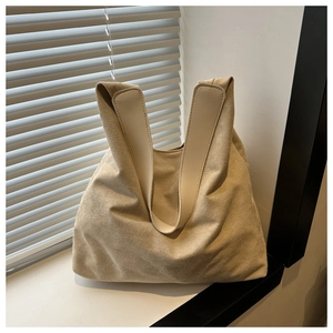 Detailed view of the apricot suede tote bag with leather handles and fine stitching accents