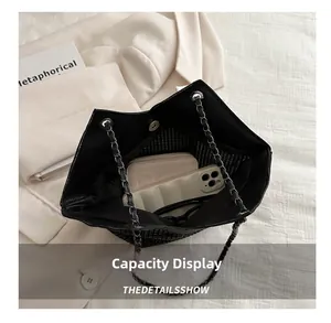 Vue intérieure d'un sac cabas noir avec compartiments pour téléphone et portefeuille