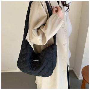 Détail du sac hobo matelassé noir avec étiquette de mode et texture rembourrée douce