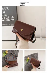 Detail of coffee brown retro flap bag with gold flower buckle and wide printed strap