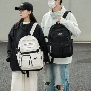 Detail of cargo style backpacks in black and white featuring fashion ribbon accents