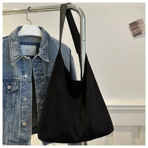 Detail view of large matte black tote bag in soft faux suede with seamless shoulder strap