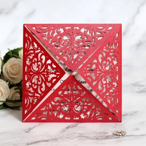 Elegante invito di nozze rosso tagliato al laser con motivi floreali su sfondo di marmo bianco