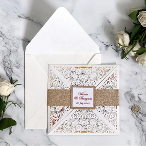 Laser cut lace wedding invitation with elegant gold glitter belly band and floral pattern