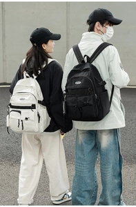 Detail view of large capacity nylon backpack showing multiple zipper pockets and buckles