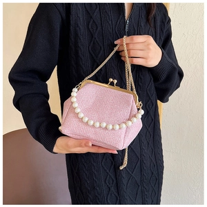 Pink glitter evening bag with pearl handle and gold metal clasp worn with black sweater